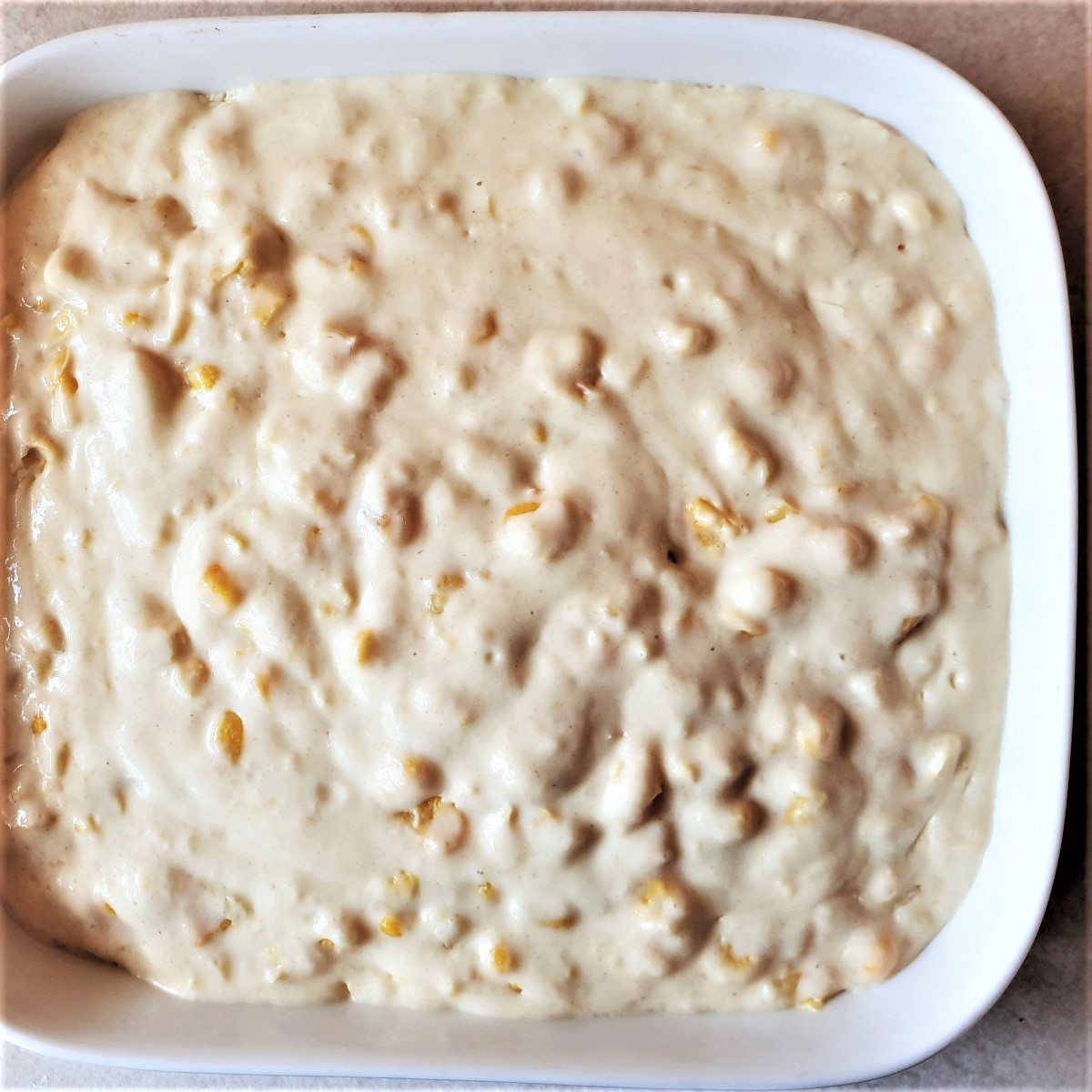 A dish of cornbread casserole batter ready for the oven.