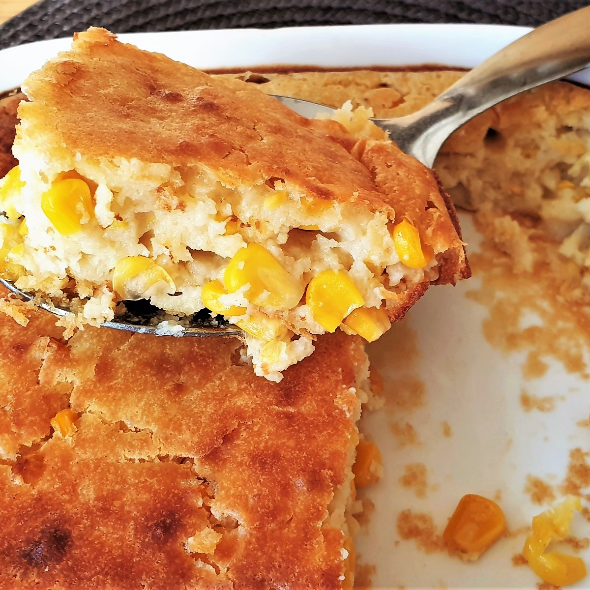 A slice of cornbread casserole bake on a spoon.