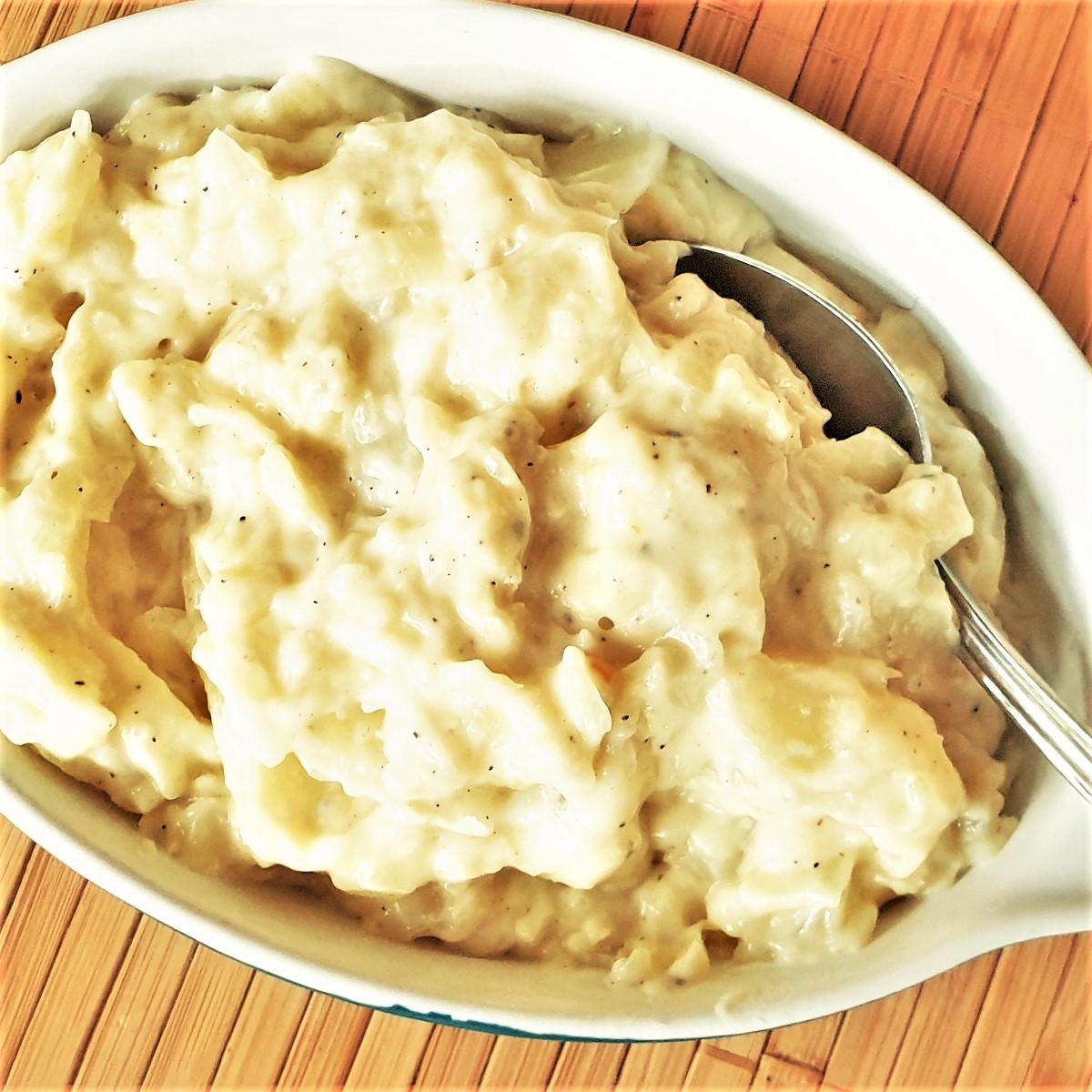 A dish of creamed cabbage with a spoon.