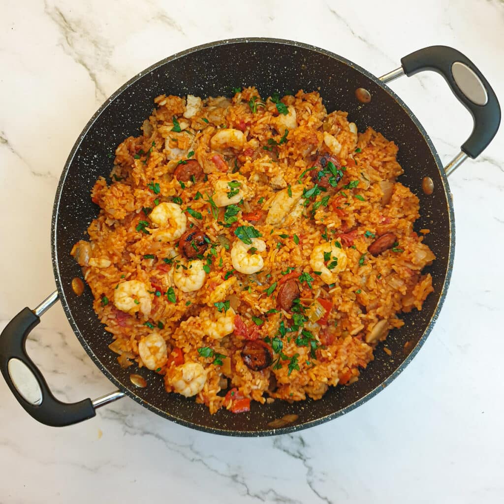 Creole jambalaya in a pan, garnished with parsley.