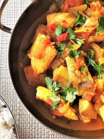 Easy fish curry in a bowl next to a bowl of rice.