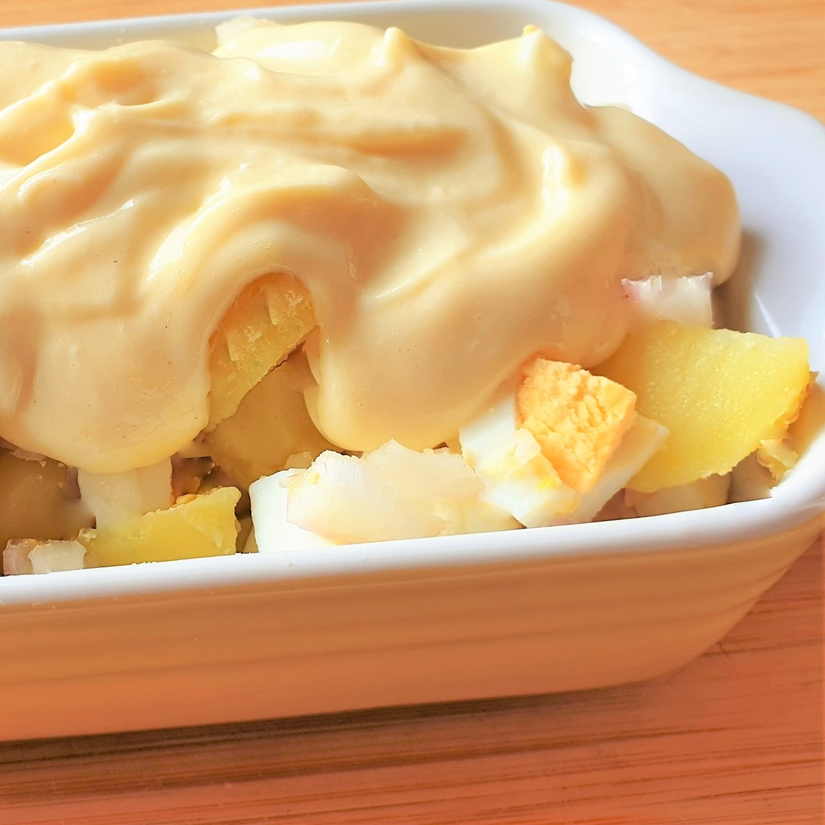 Homemade mayonnaise on a bowl of potato salad.