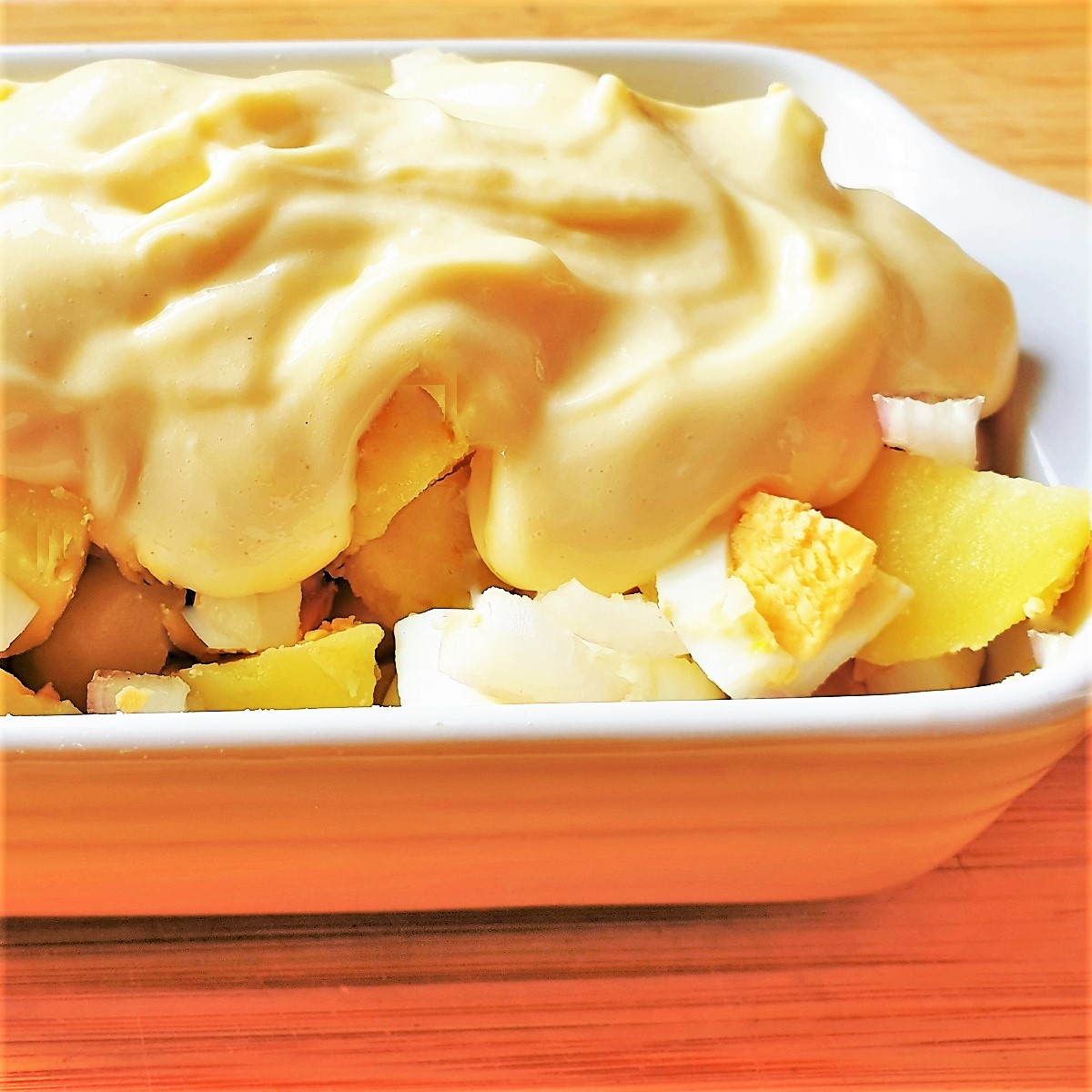 Potato salad covered with mayonnaise.