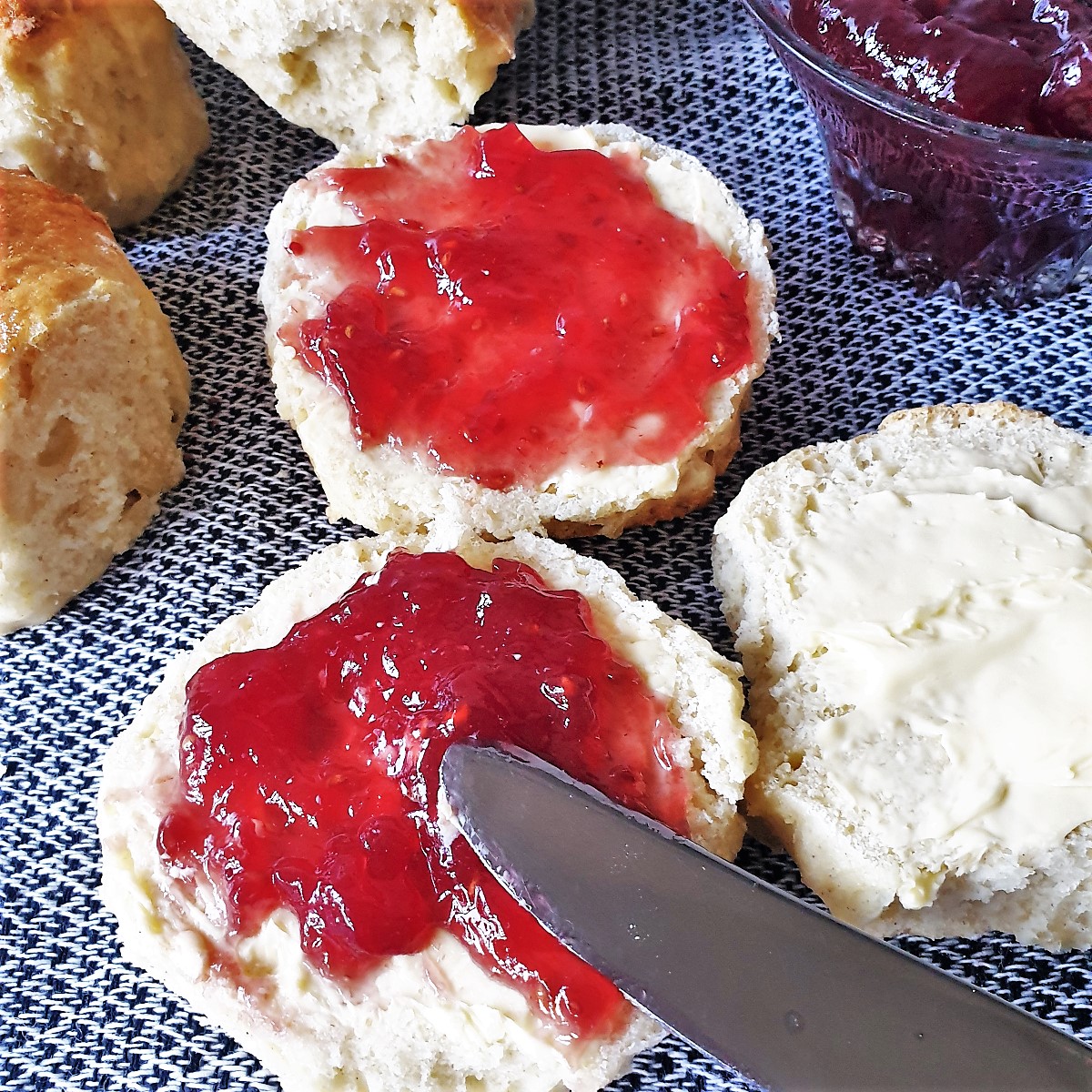 A scone being spread with jam.