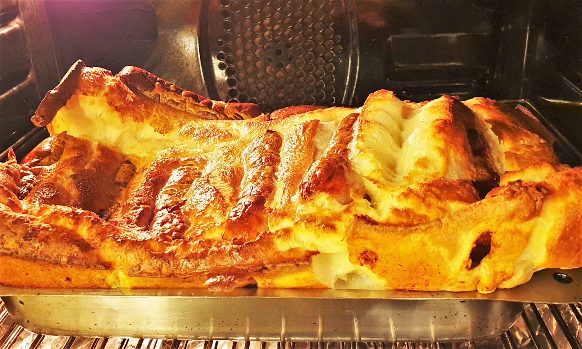 A dish of toad in the hole baking in the oven.