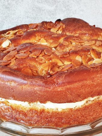 An side on view of a bee sting cake showing the rise of the cake, the filling and the crunch almond topping.