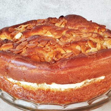 An side on view of a bee sting cake showing the rise of the cake, the filling and the crunchy almond topping.