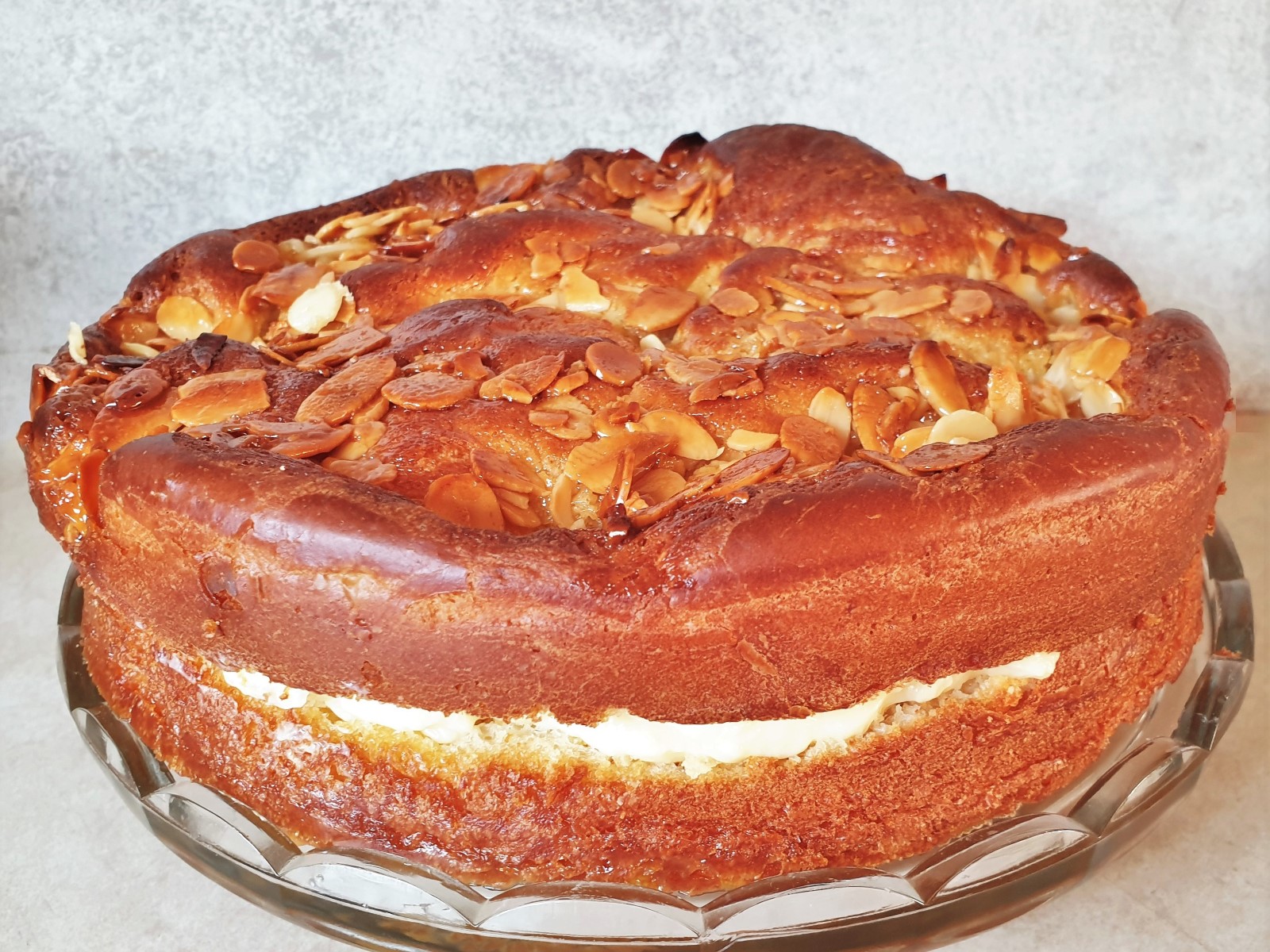 An side on view of a bee sting cake showing the rise of the cake, the filling and the crunch almond topping.