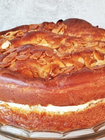 An side on view of a bee sting cake showing the rise of the cake, the filling and the crunch almond topping.