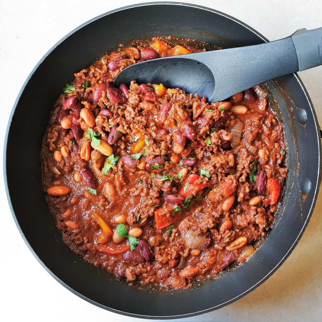 Chilli con carne in a pan with a spoon