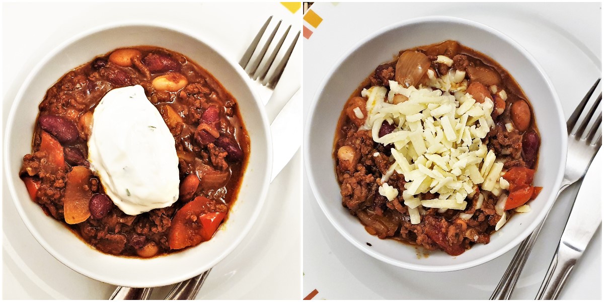 Two bowls of chilli, one topped with sour cream and the other topped with grated cheese.