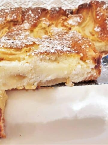 A closeup of a slice of fresh pear cream slice on a cake lifter.