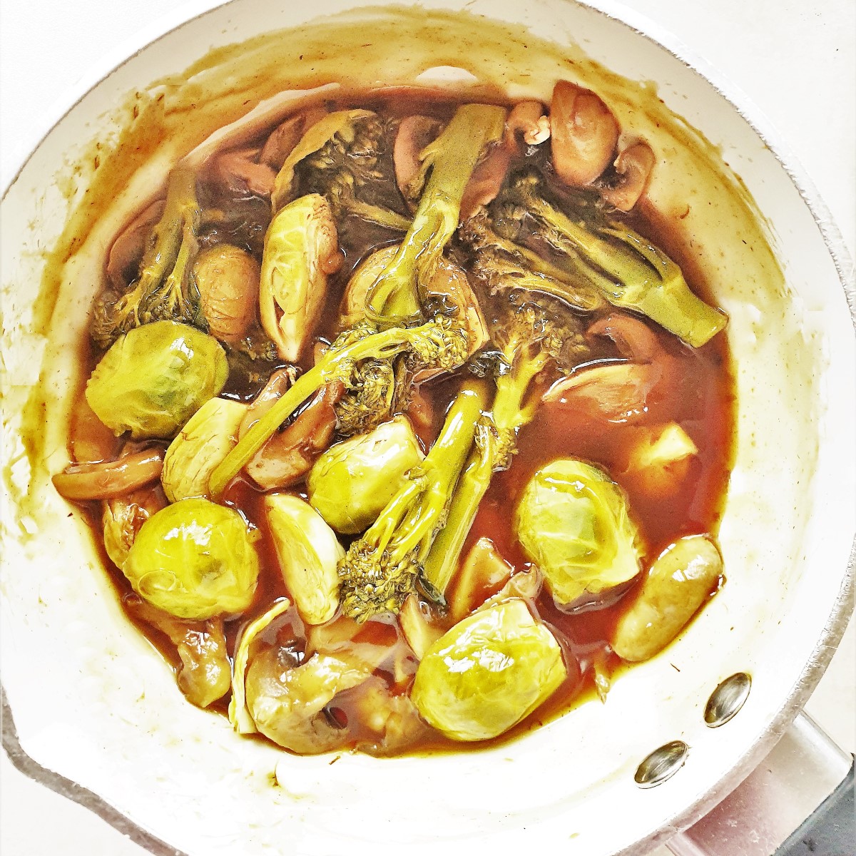 A pan of vegetables in a garlic sauce.