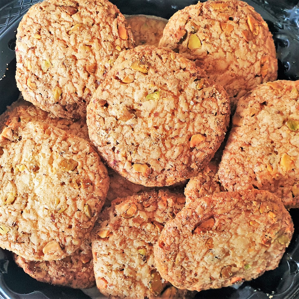 A heap of baked pistachio butter biscuits on a plate.