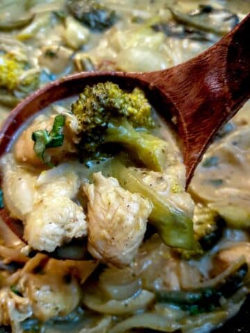 Close up of Thai green curry chicken being spooned from a serving dish.