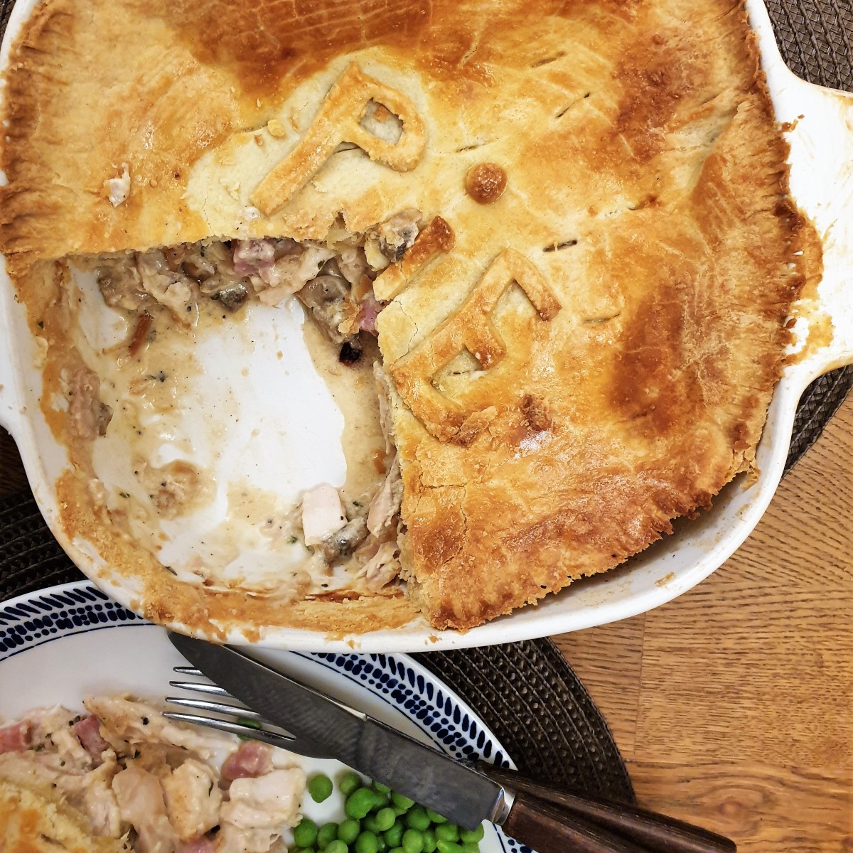 Overhead shot of chicken and ham pie with a slice removed.