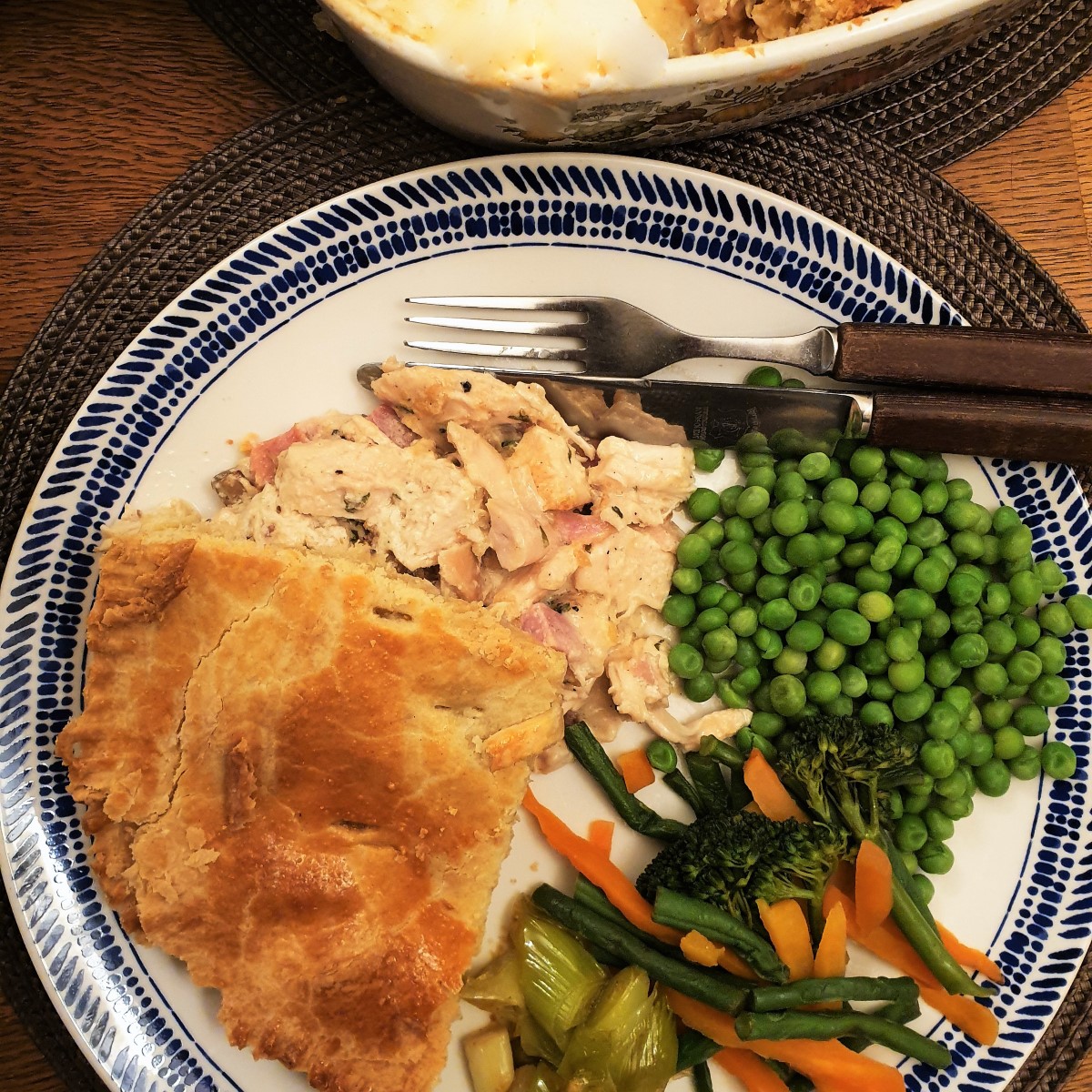 A plate of chicken and ham pie with vegetables,