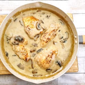 Overhead shot of chicken marsala swimming in creamy mushroom sauce in a frying pan.