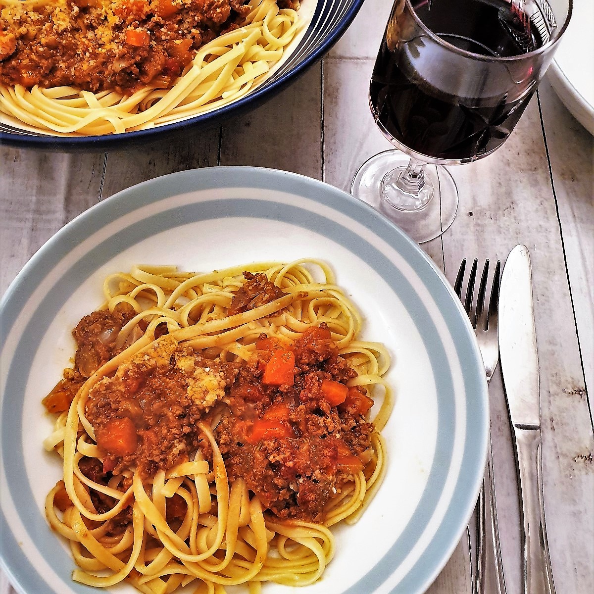 A bowl of lamb ragu on a bed of linguine.