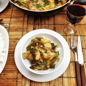 A table set with a bowl of thai green curry next to a dish of jasmine rice.