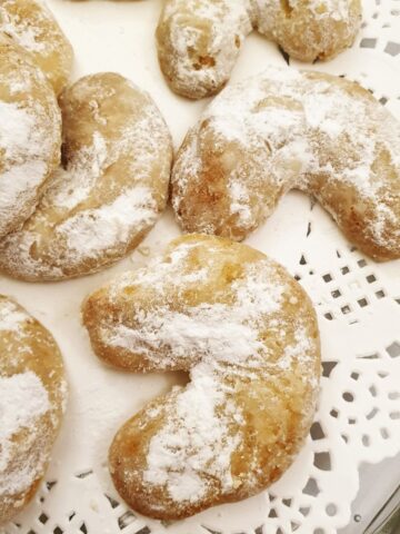 Walnut crescent cookies on a doily.