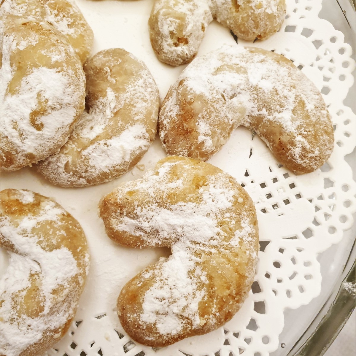 Walnut crescent cookies on a doily.