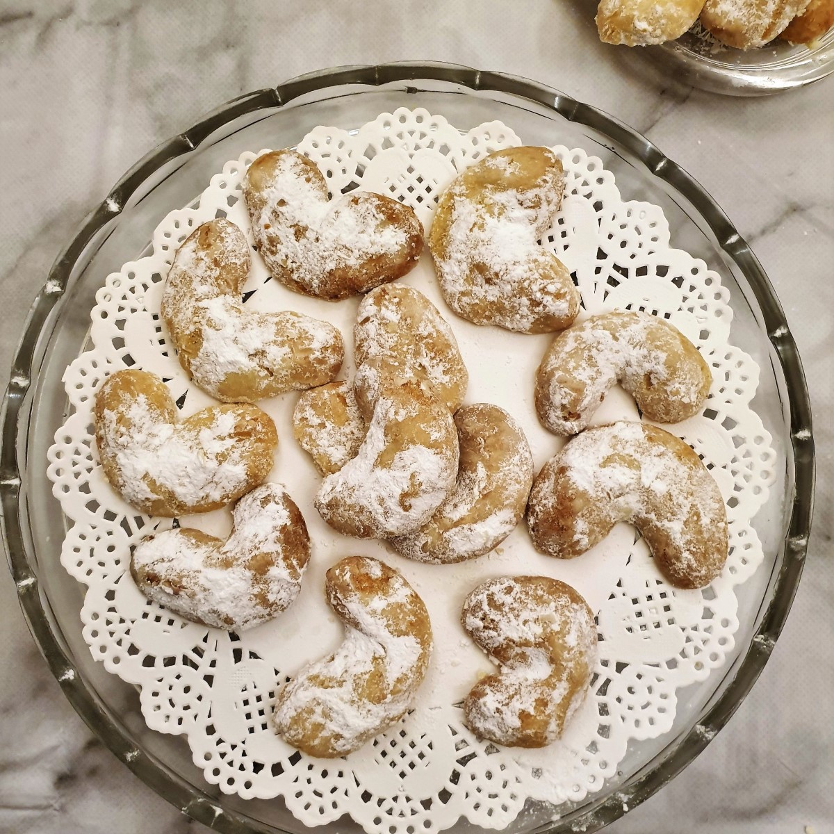 Overhead shot of vanillekipferl on a glass serving dish.