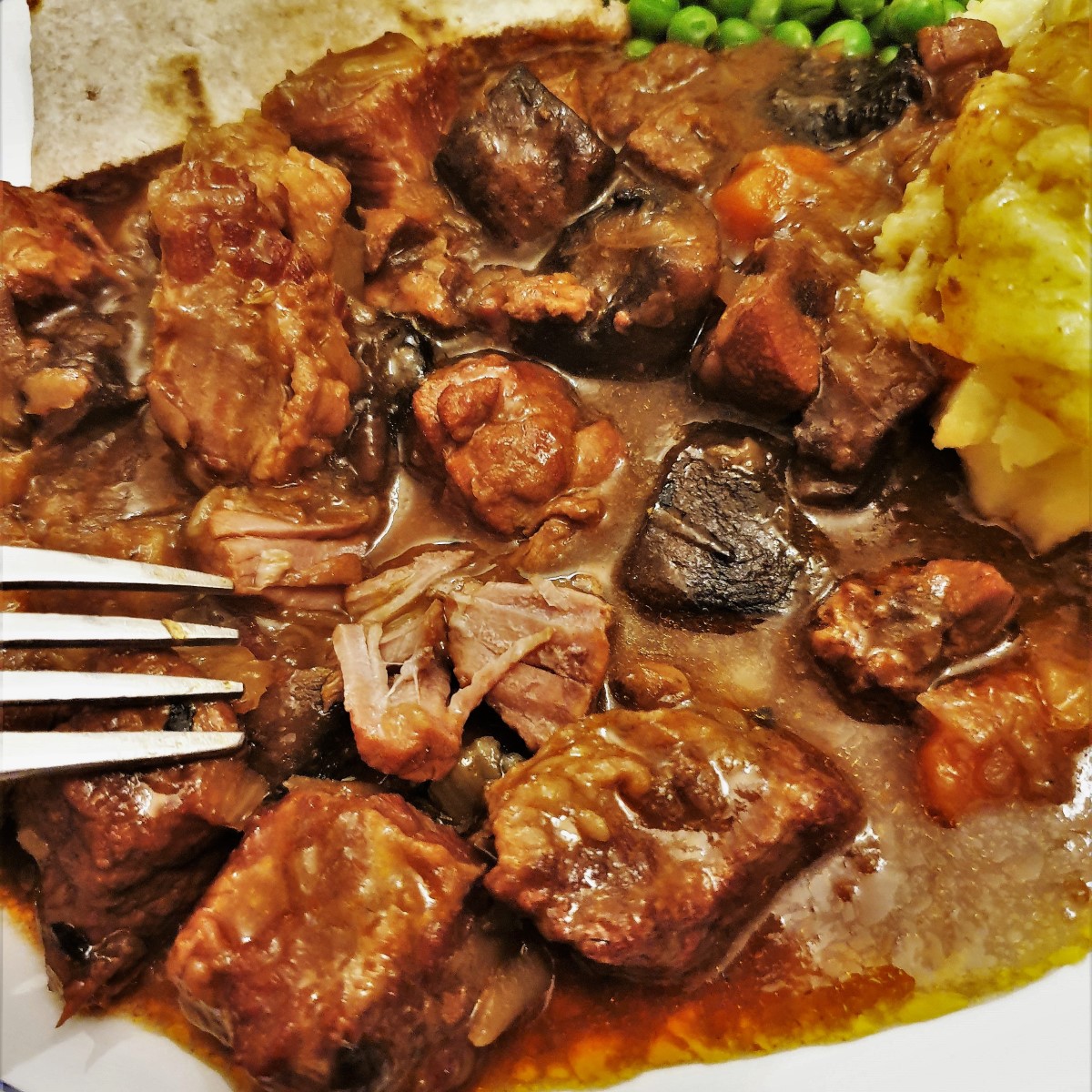 A hearty beef and kidney stew, slow-cooked until you can cut the meat with a fork! And I've also got three secret tips for making the tastiest, thickest gravy, without the need for thickening agents. #foodleclub homemade #steakandkidney #beefstew #slowcookerstew Close up of steak and kidney stew showing how the meat falls apart.