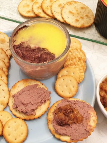 A dish of chicken liver pate with biscuits.