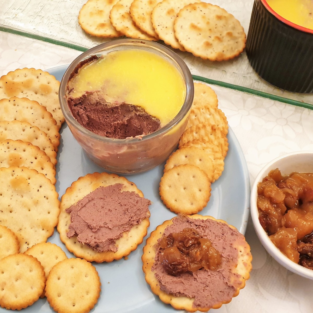 A dish of chicken liver pate with biscuits.