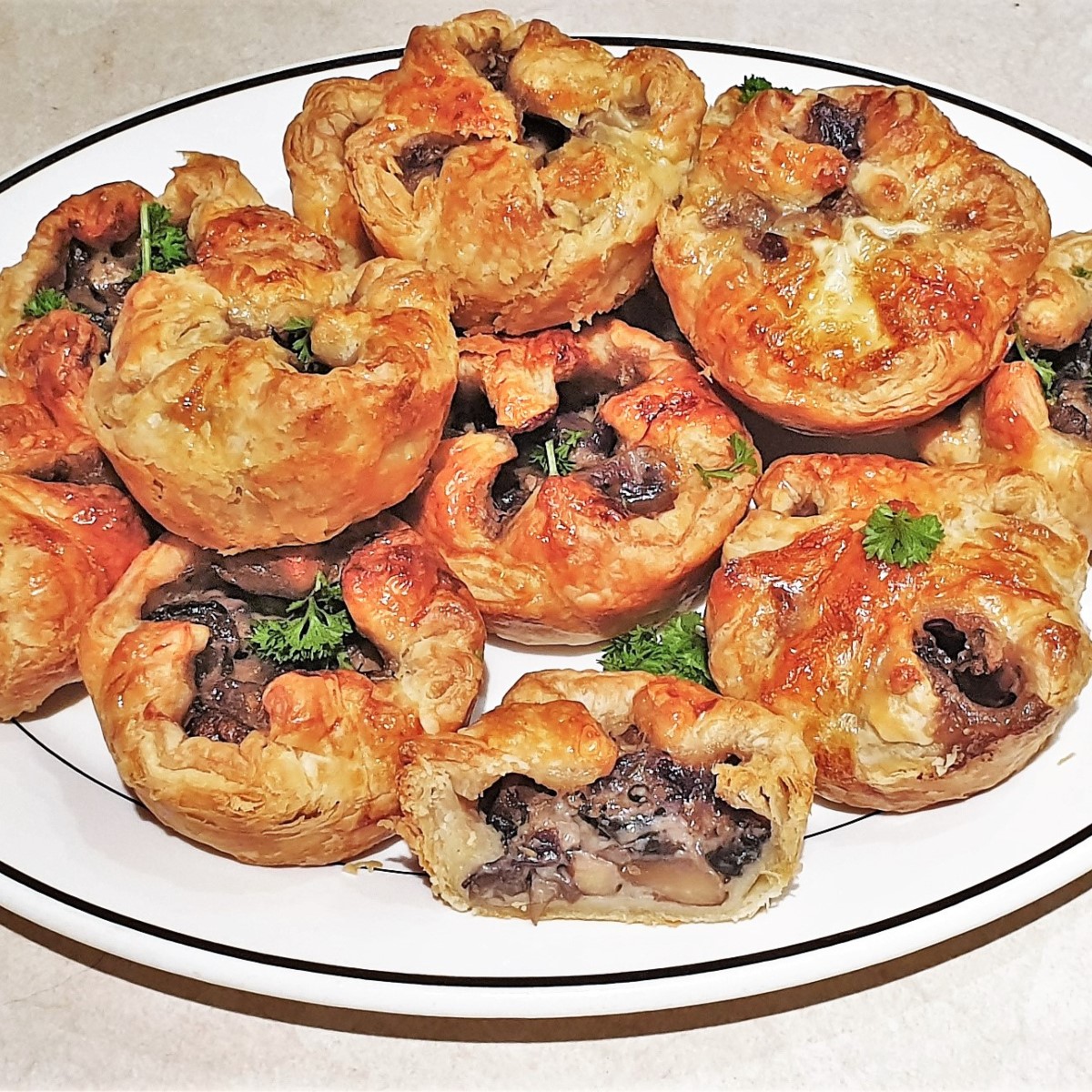 A serving dish piled with mushroom tarts.