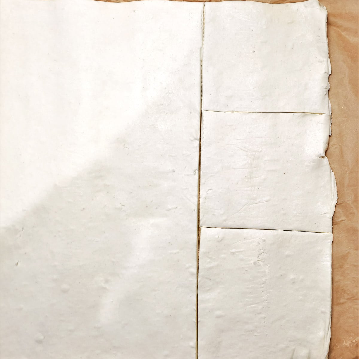 A sheet of puff pastry cut into squares.