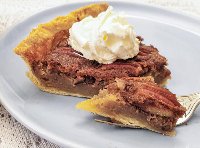 A slice of pecan nut pie on a plate.