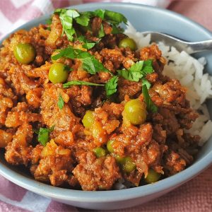 Beef curry and rice in a dish with a fork.