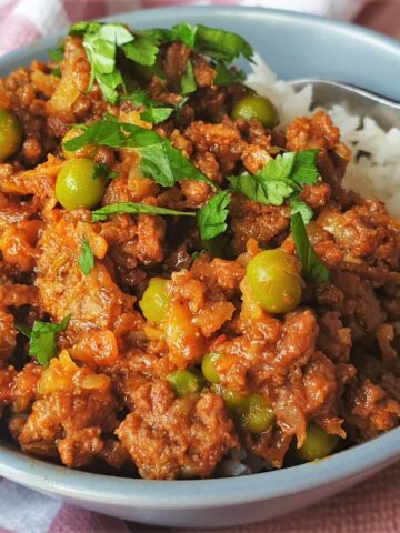 Beef curry and rice in a dish with a fork.