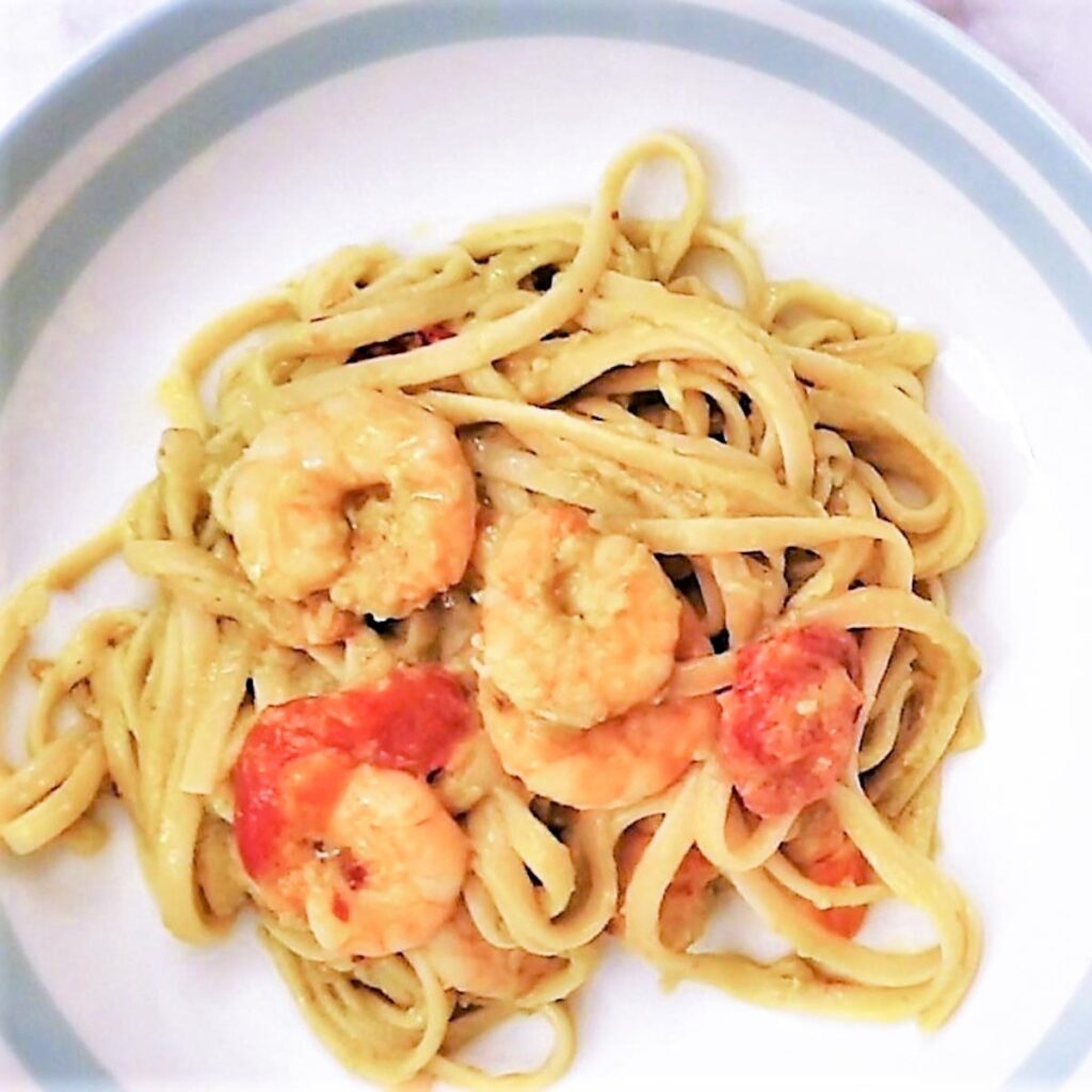 Close up of avocado and shrimp linguine on a plate.