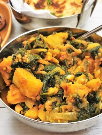 Close up of a balti dish filled with saag aloo.