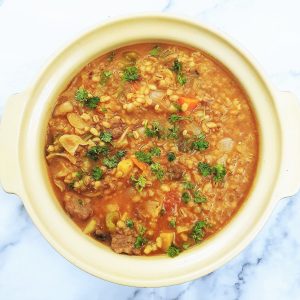 Overhead shot of beef and barley stew in a casserole dish.