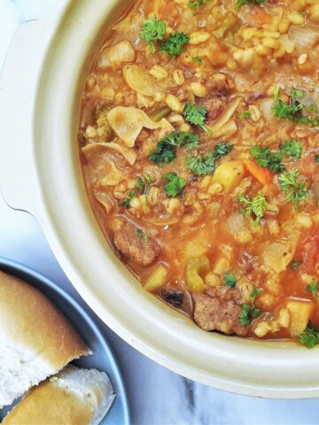 Closeup of beef and barley stew with crusty bread.