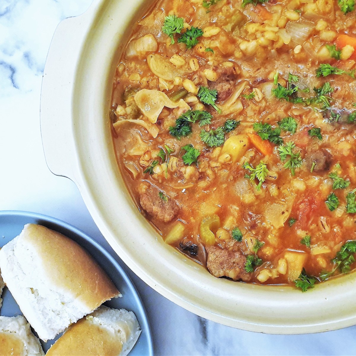 Closeup of beef and barley stew with crusty bread.