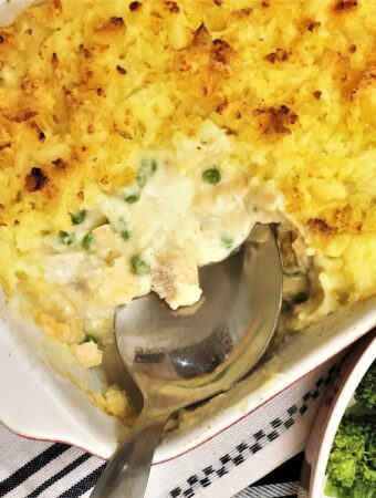 Fish pie with a spoon removing a corner to show the inside.