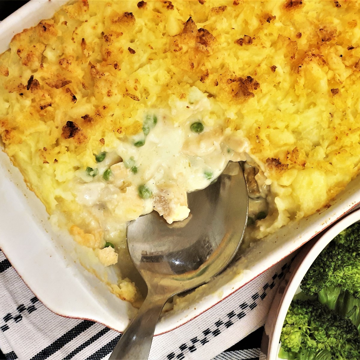 Fish pie with a spoon removing a corner to show the inside.