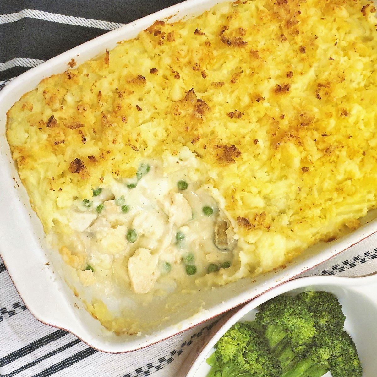 A fish pie with a spoonful removed to show the fish inside.
