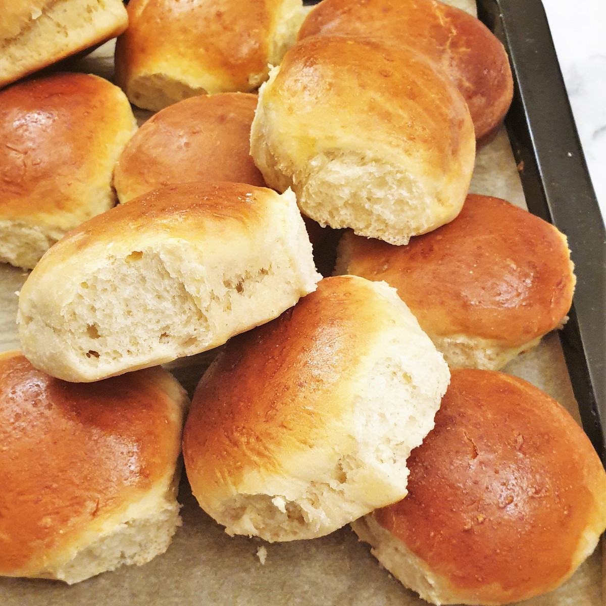 A pile of soft dinner rolls fresh from the oven.