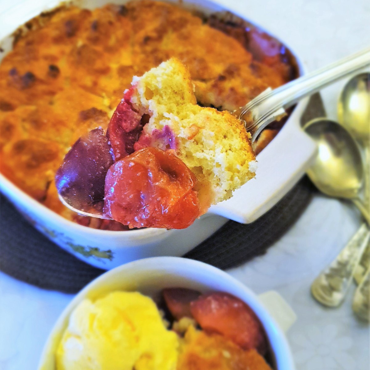 Closeup of a spoonful of plum cobbler.