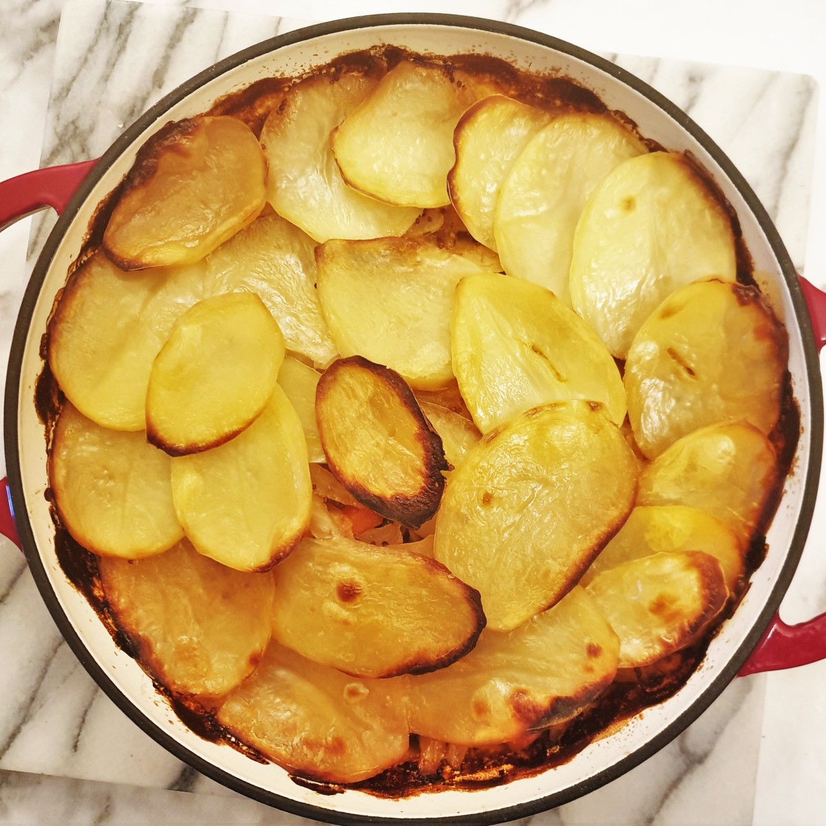 Pork and cabbage hotpot covered with a layer of crispy potatoes.