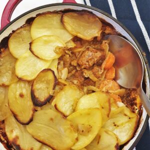 Pork and cabbage hotpot with some of the potatoes removed to show the inside.