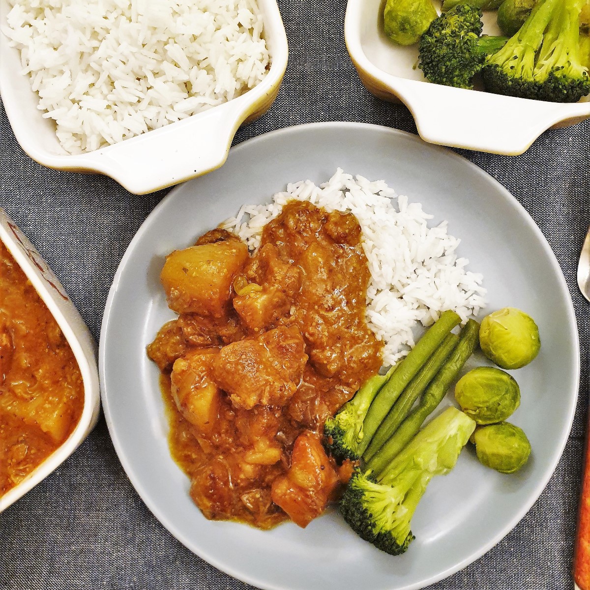 Honey mustard pork casserole on a blue plate with rice and vegetables.