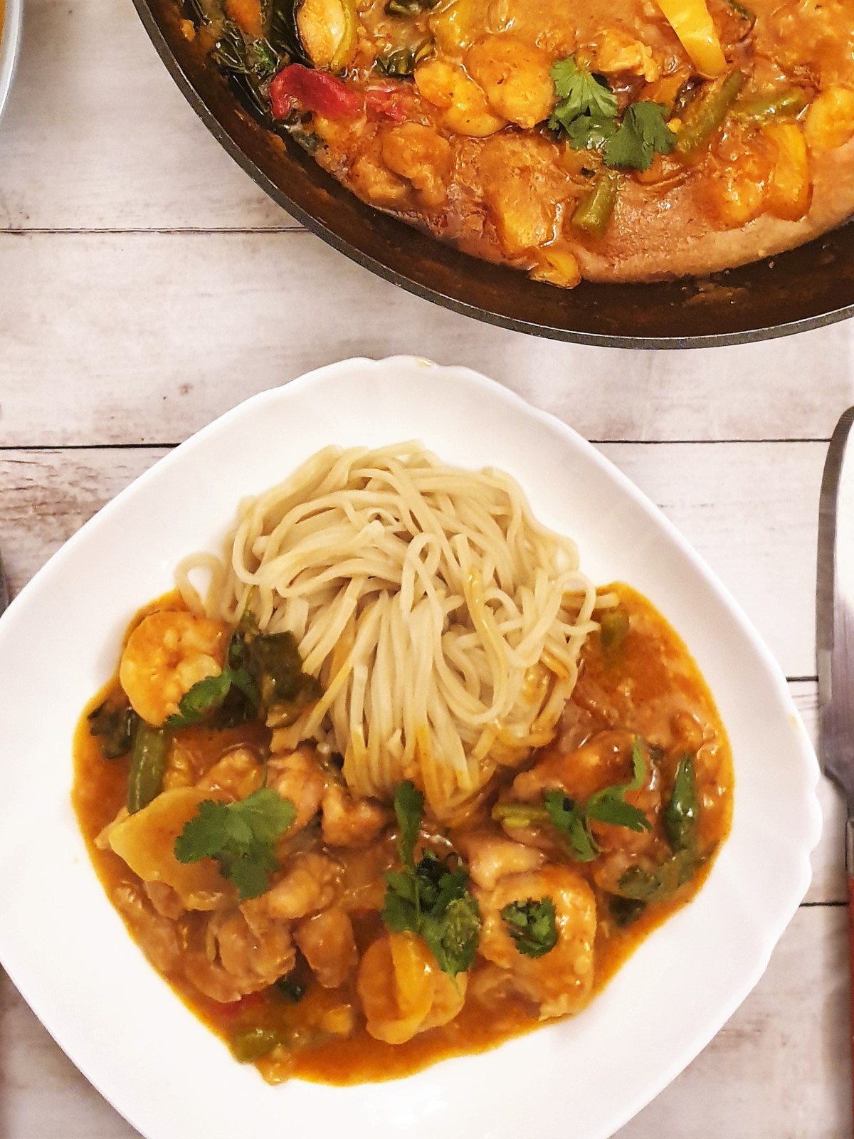 Overhead shot of Thai red curry with a pile of noodles.