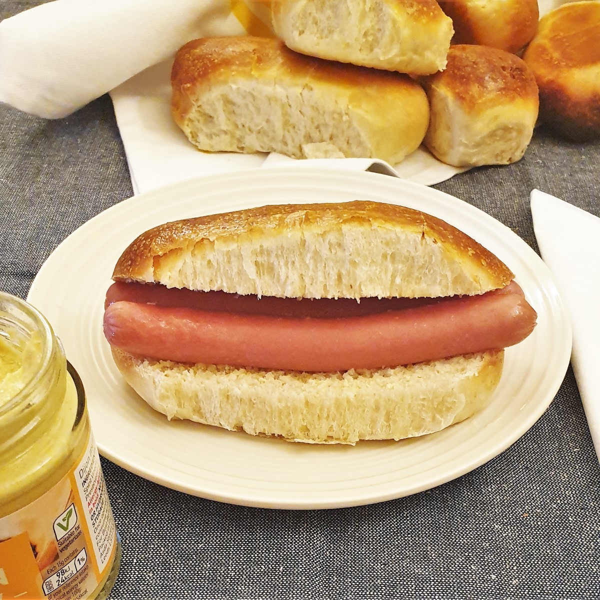 A hot dog in a roll on a plate.